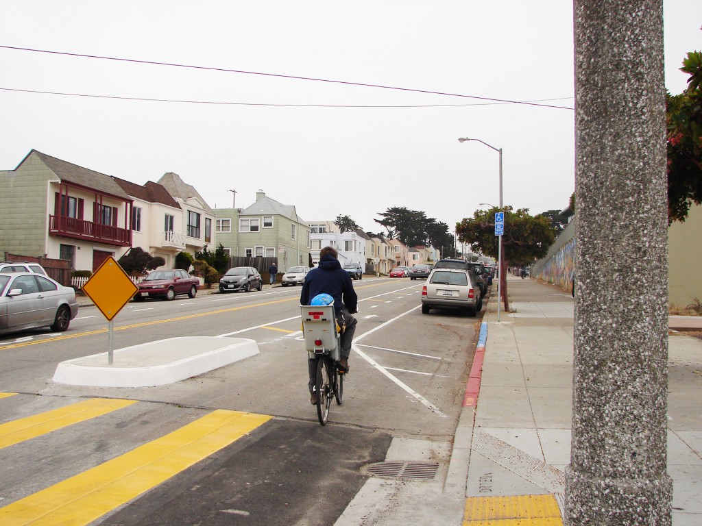 This family of three rides on the new bike lanes right in front of Sunset Elementary School on the opening day.