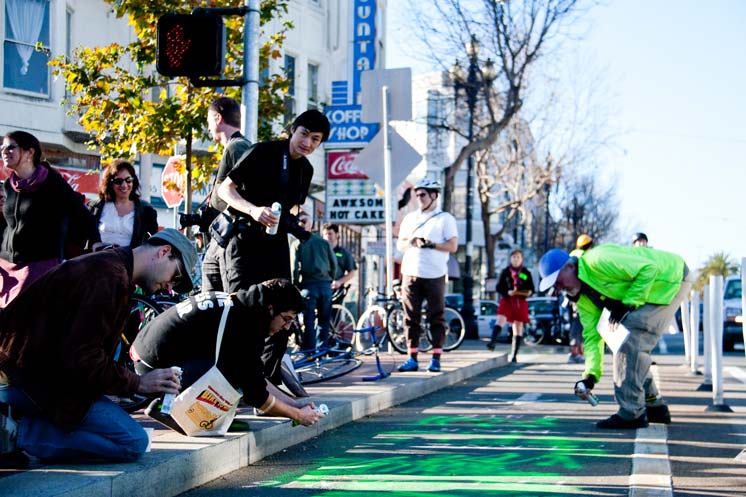 Four of us SF Bicycle Coalition members and staff spraying what a green bike lane could look like on January 16, 2009 before it became a reality. (Photo by former Membership and Volunteer Director Kate McCarthy)